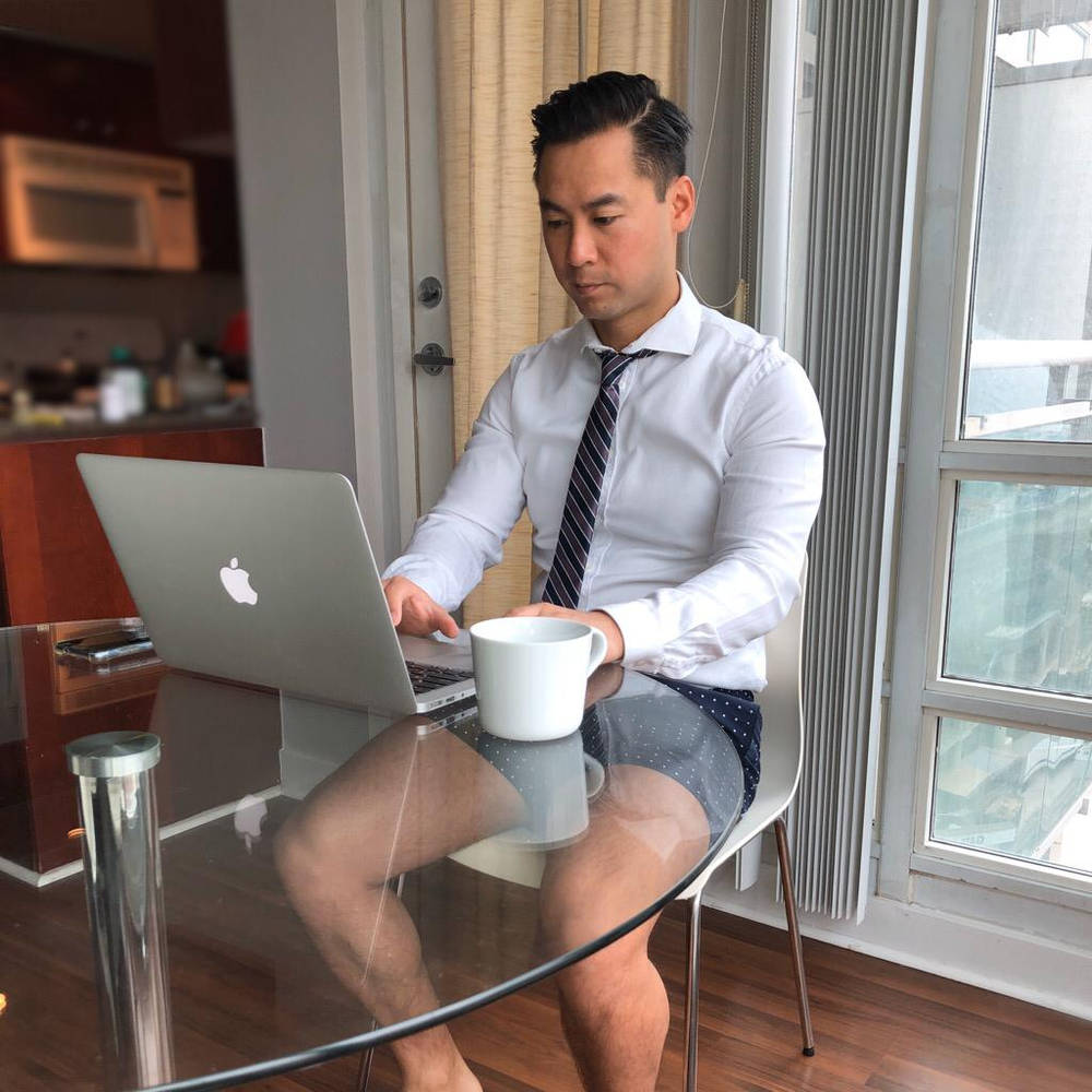 During Covid 19, physiotherapist working from home wearing dress shirt, tie, and shorts