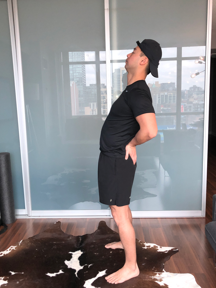 Standing, bend backward to stretch lower back