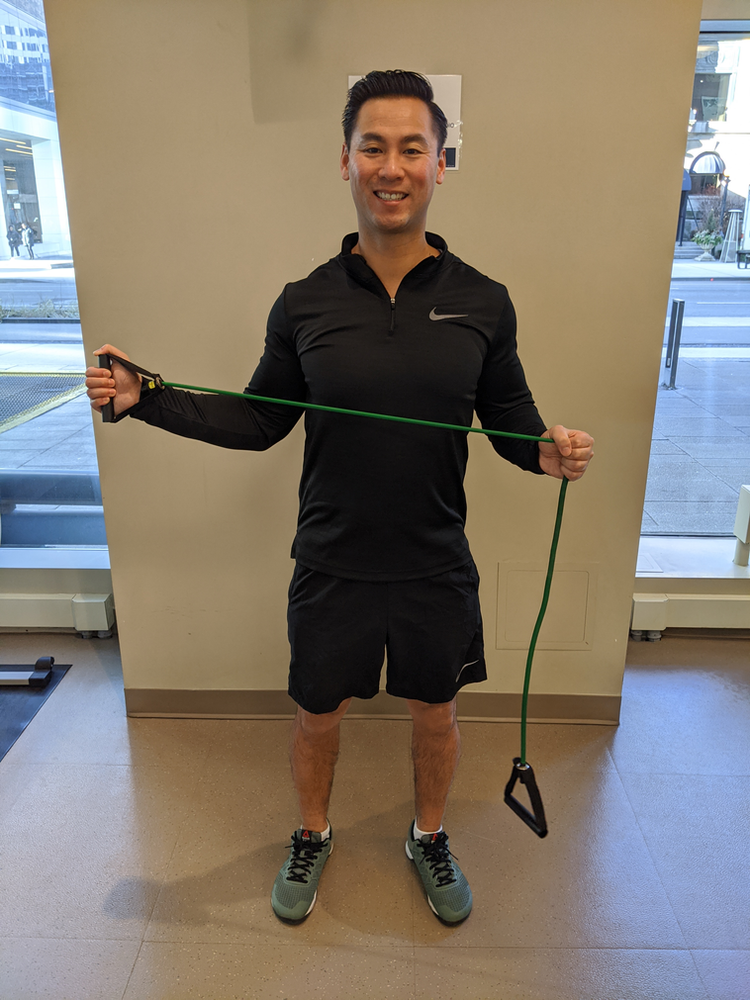 Physiotherapist Eric Lau demonstrating a banded shoulder external rotation exercise.