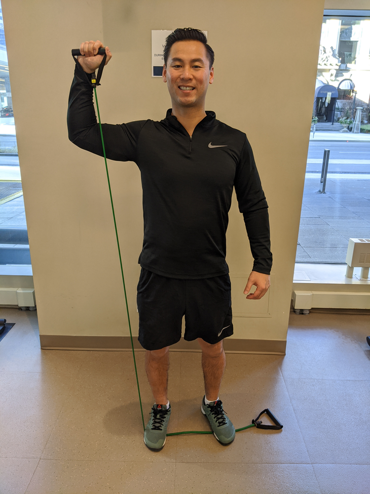 Physiotherapist Eric Lau demonstrating a 90/90 shoulder external rotation to overhead press exercise.