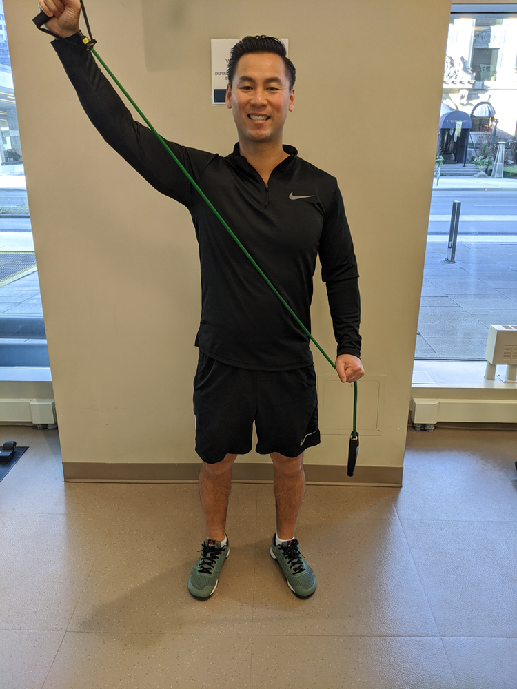 Physiotherapist Eric Lau demonstrating a banded pulling out the sword exercise.