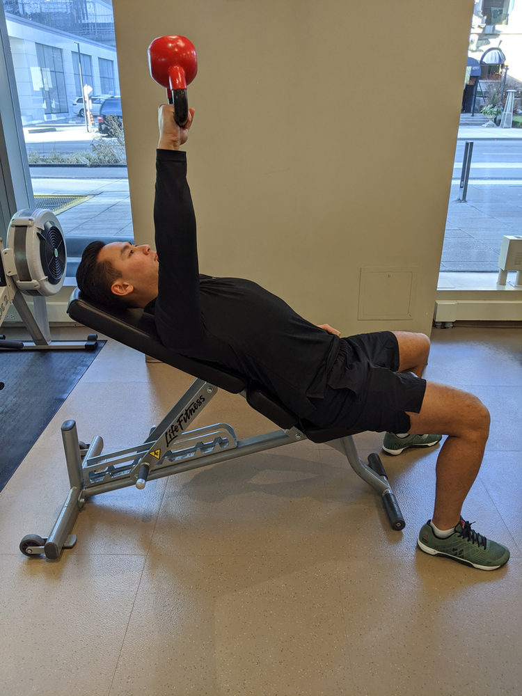 Physiotherapist Eric Lau demonstrating a incline kettle bell chest press exercise
