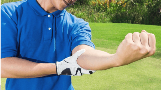 Golfer grimacing as he holds his left elbow in pain