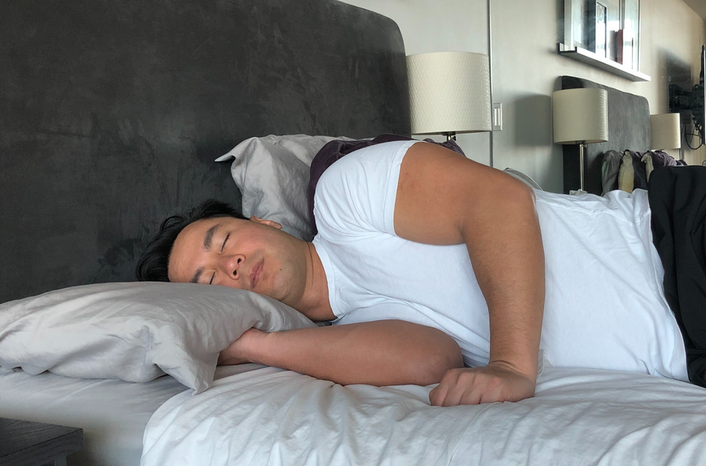 Man sleeping on his side on a mattress