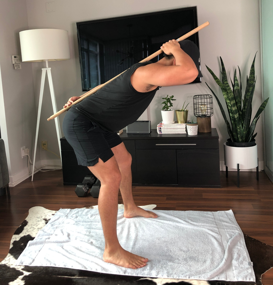 hip hinge exercise with dowel along back