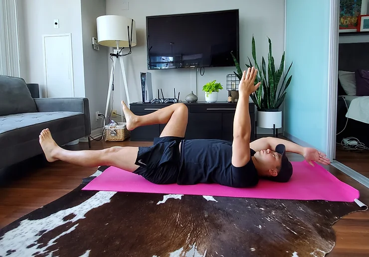Physiotherapist Eric Lau demonstrating a dead bug exercise.