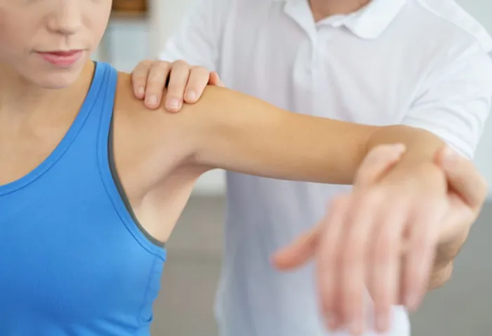 A physiotherapist treating a patient for her shoulder impingement injury
