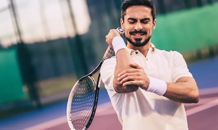 Male tennis player suffering from tennis elbow