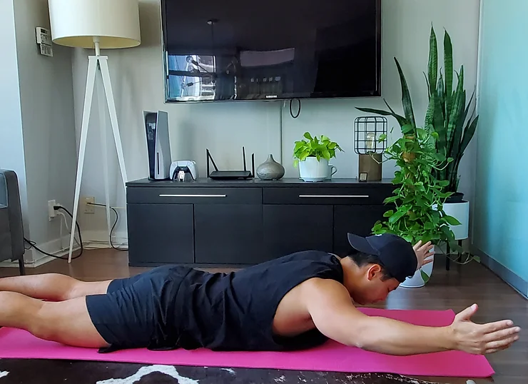 Physiotherapist Eric Lau performing a prone floor angel exercise.