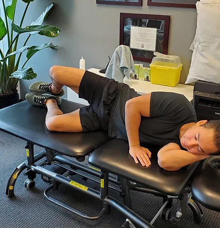Physiotherapist Eric Lau is demonstrating a clam shell exercise.