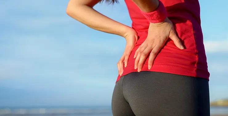 Women suffering from piriformis syndrome is rubbing her buttock.
