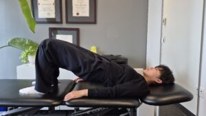 Physiotherapist Gahoi Kim demonstrating a bridge exercise