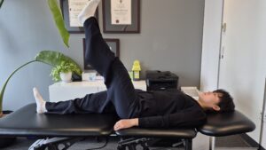 Physiotherapist Gahoi Kim demonstrating a banded straight leg raise exercise