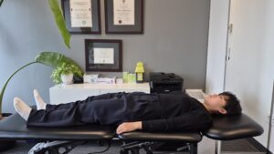 Physiotherapist Gahoi Kim demonstrating a banded straight leg raise exercise