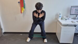 Physiotherapist Gahoi Kim demonstrating a banded crab walk exercise.