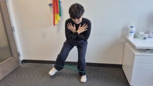 Physiotherapist Gahoi Kim demonstrating a banded crab walk exercise.