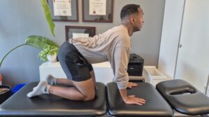 Physiotherapist Najih Ismail demonstrating the cat portion of this cat camel exercise.