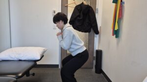 Physiotherapist Gahoi Kim demonstrating mini squat exercise.