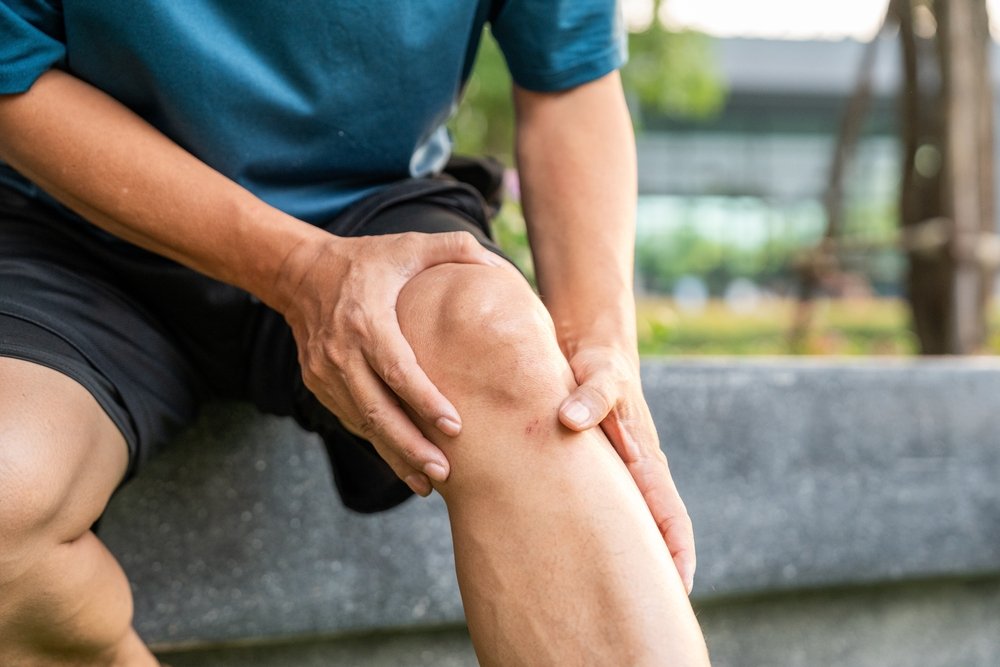 man holding sore left knee