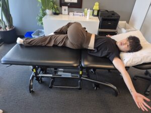 Physiotherapist Gahoi Kim performing Supine Spinal Twist exercise